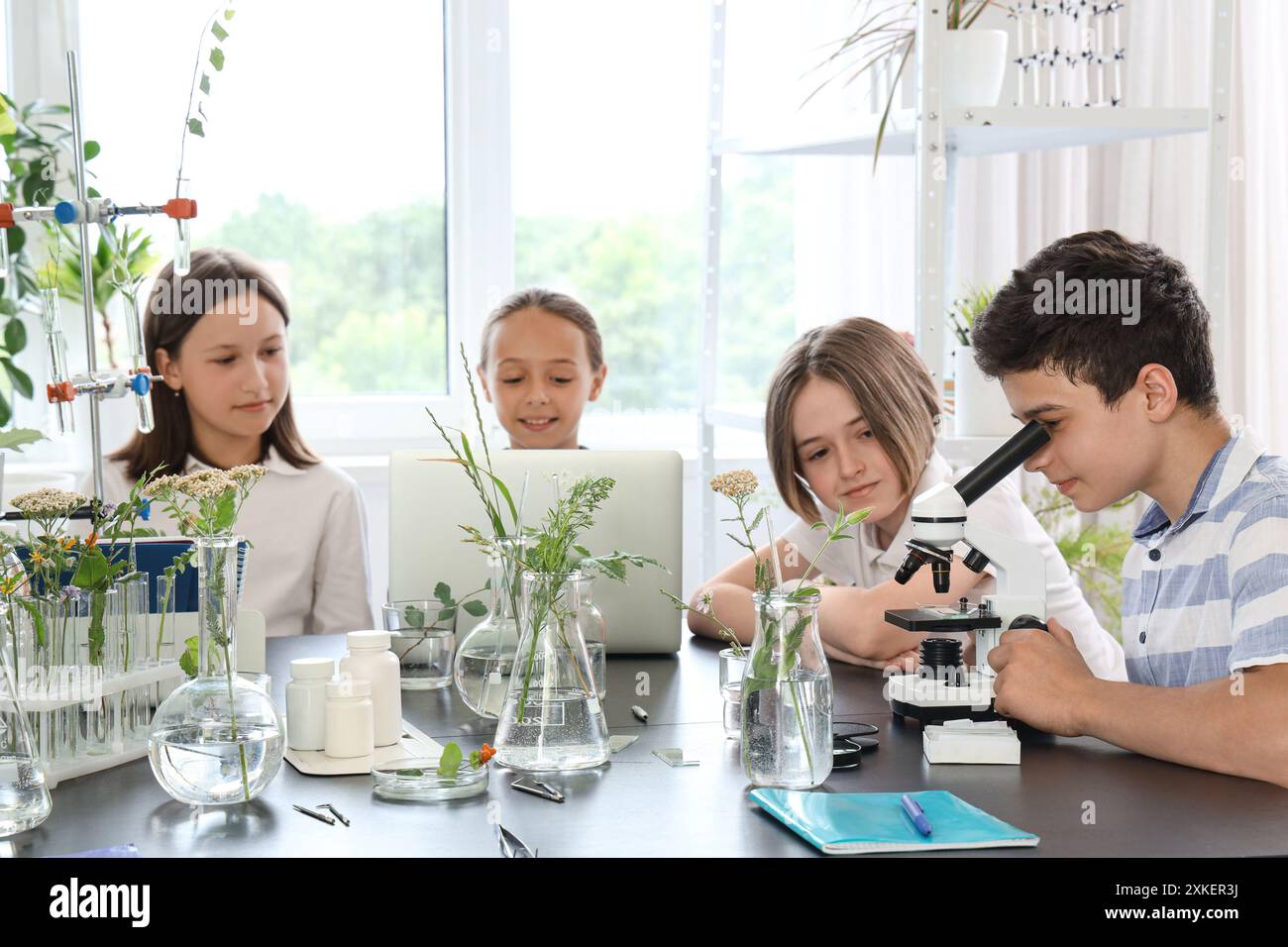 Teenage boy looking through microscope in Biology class at school Stock ...