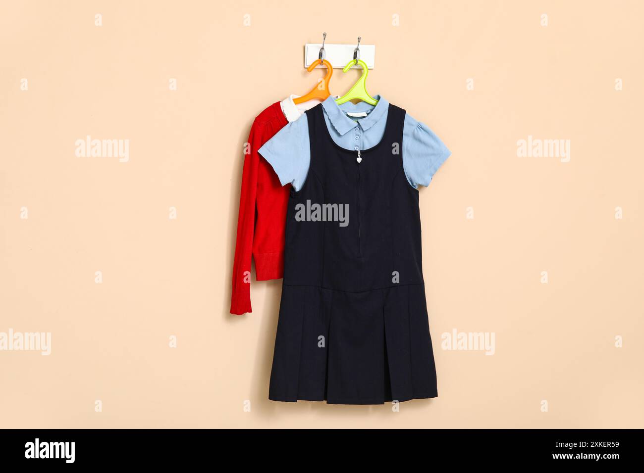 Stylish school uniform for girl hanging on color wall Stock Photo - Alamy