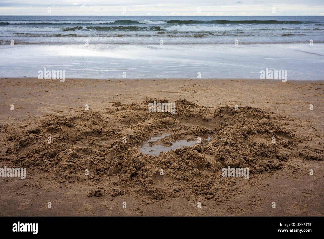 Large hole in the sand on the beach at Noosa Heads, Queensland, Australia Stock Photo