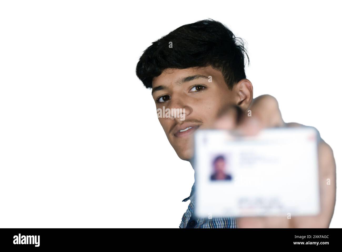 Indian school boy wearing dark blue school uniform, with smiling face shows her blurred aadhar card in his hand. Stock Photo