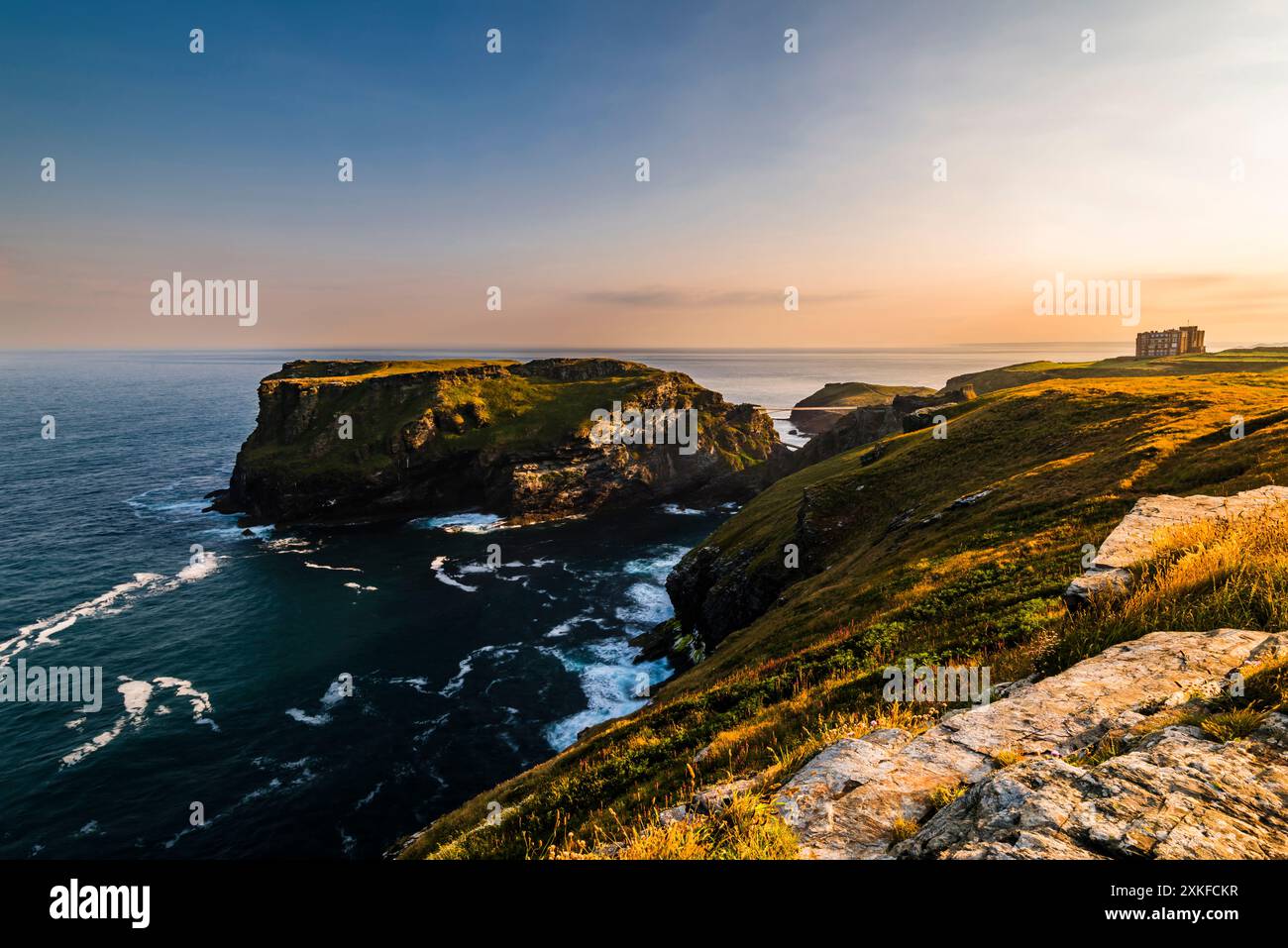 Long exposure of the sunrise light near the summer solstice glowing over Tintagel Island, Tintagel, Cornwall, UK Stock Photo