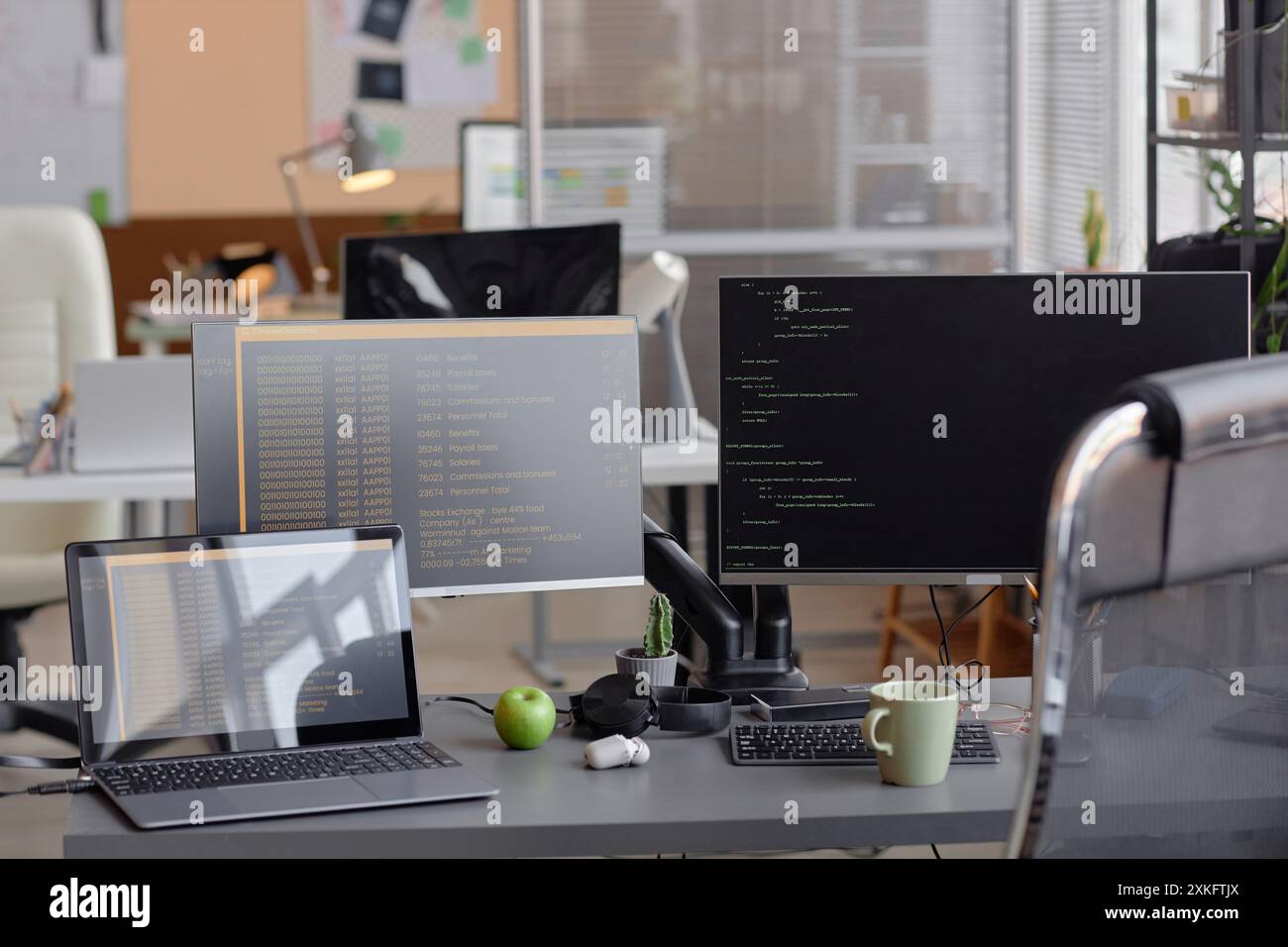 Interior of empty modern software developer office with computers on desk programming language on screen Stock Photo