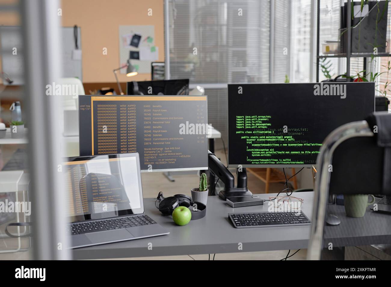 Background shot of programmer desk setup with laptop and computer ...