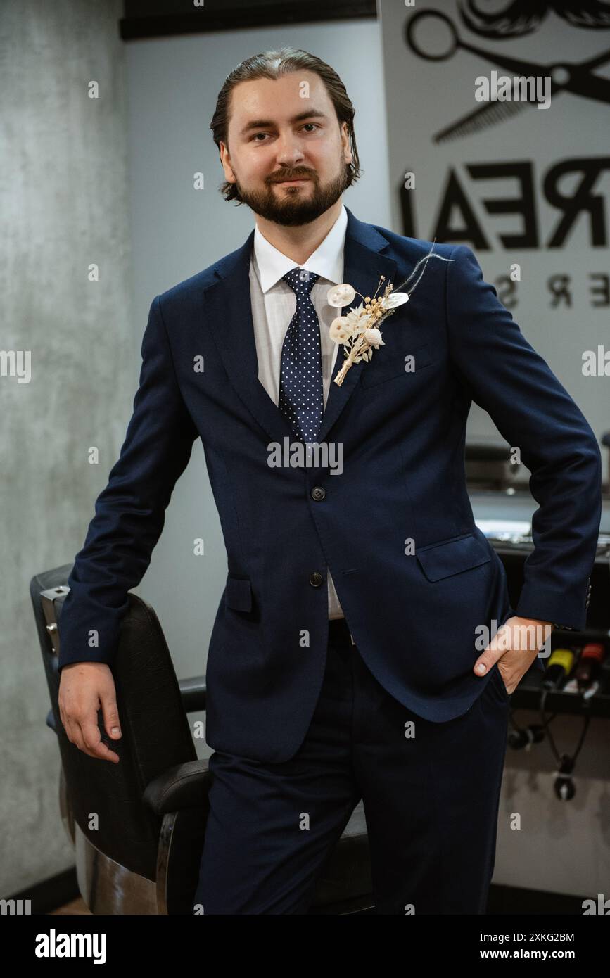 portrait of a male groom in a blue suit in the morning going to the ...