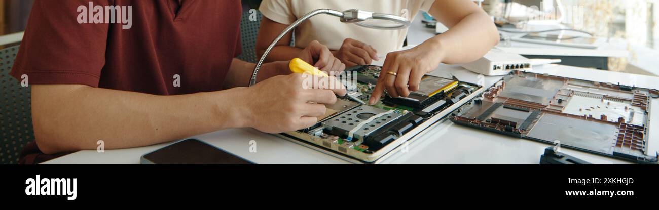 Colleagues Repairing Computer In Team Stock Photo