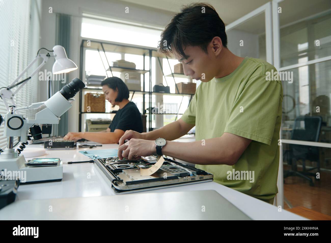 Colleagues Repairing Laptops In Workshop Stock Photo
