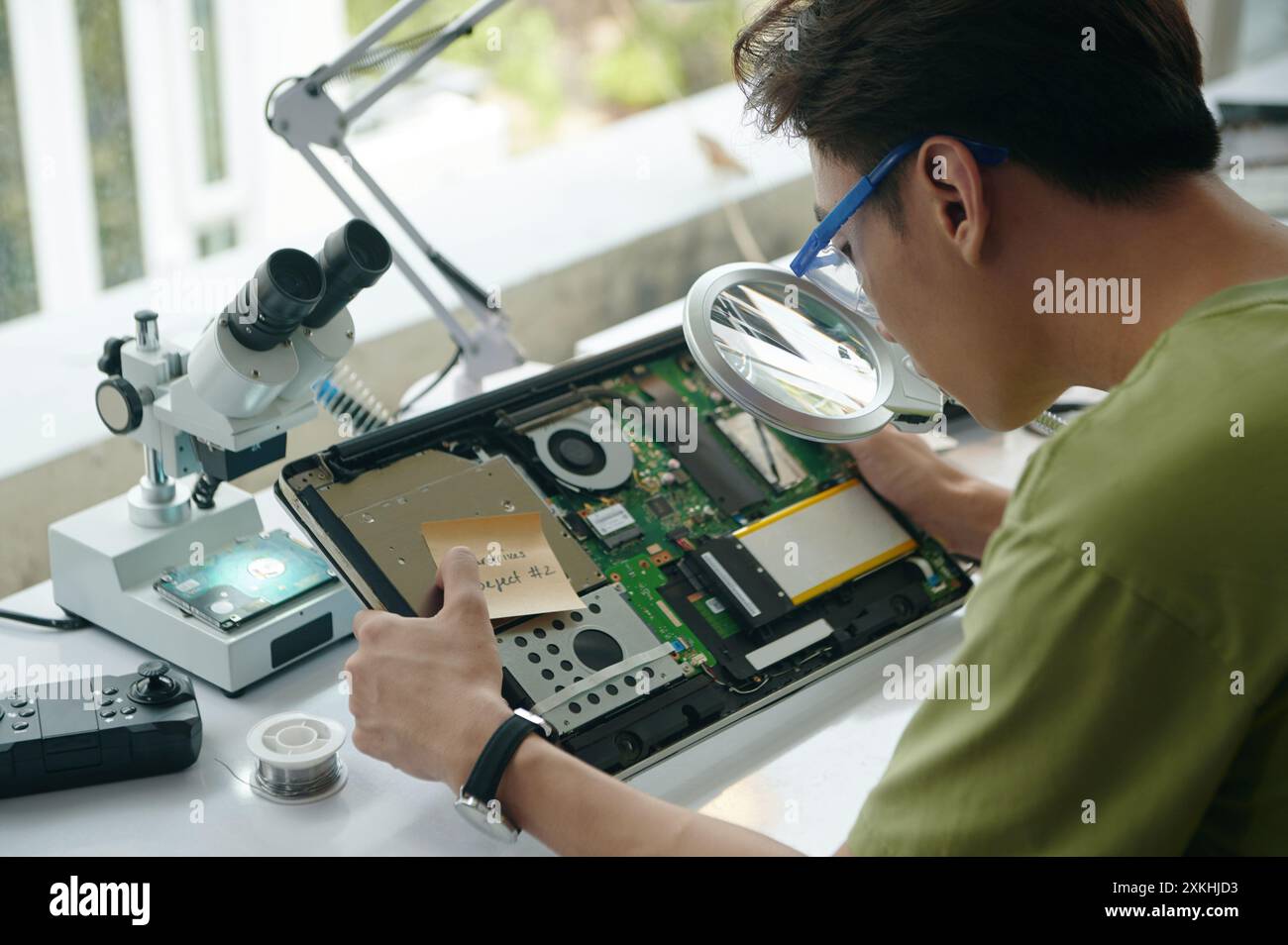 Repairman Using Magnifier At His Work Stock Photo