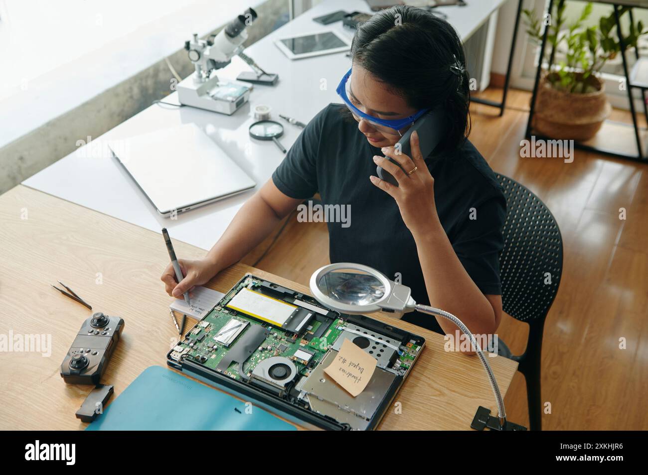 Master Making Notes During Repair Stock Photo