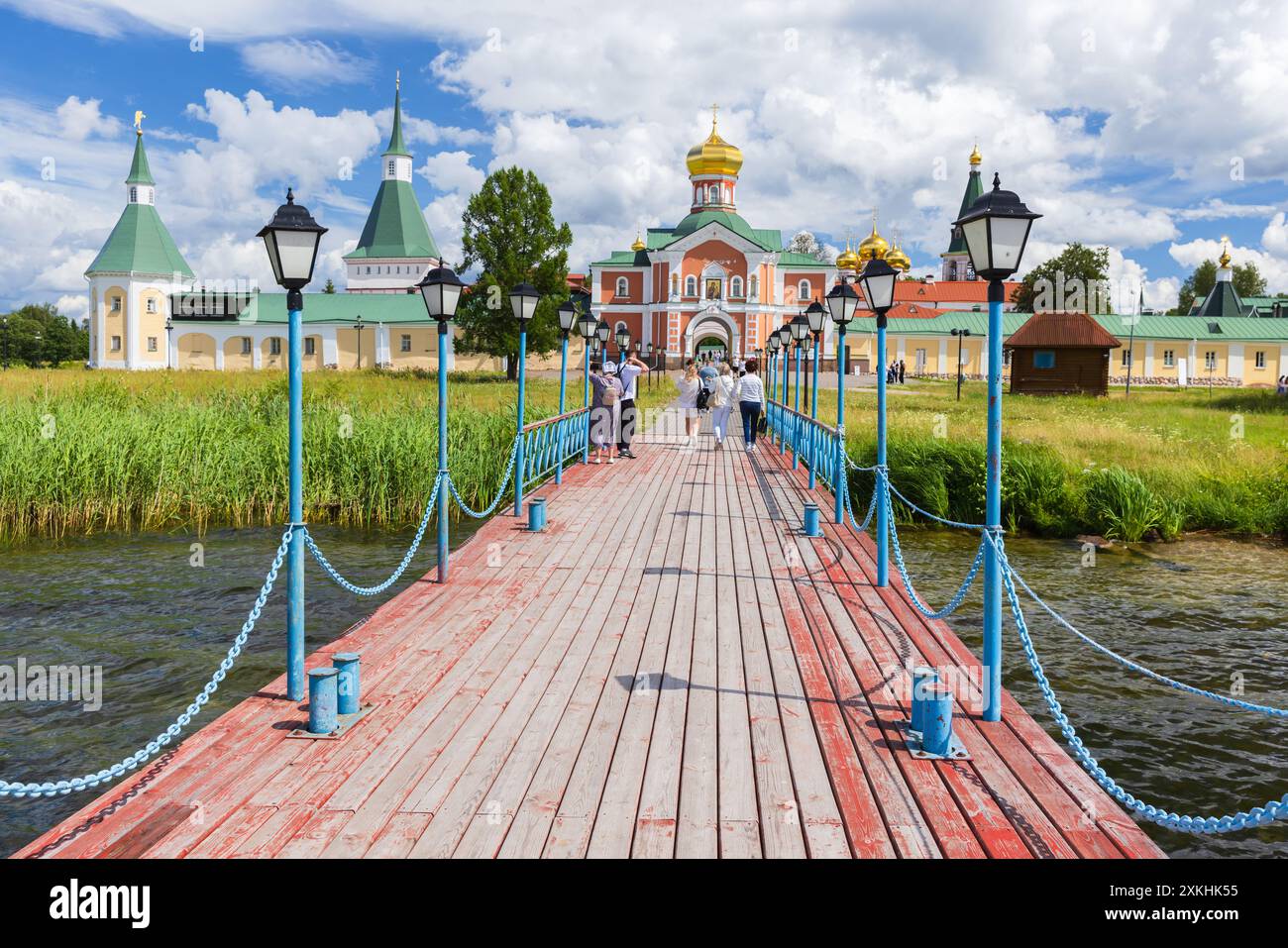 Valday, Russia - July 06, 2024: The Gate Church of Valday Iversky Monastery view from the pier, visitors are in front of the entrance Stock Photo