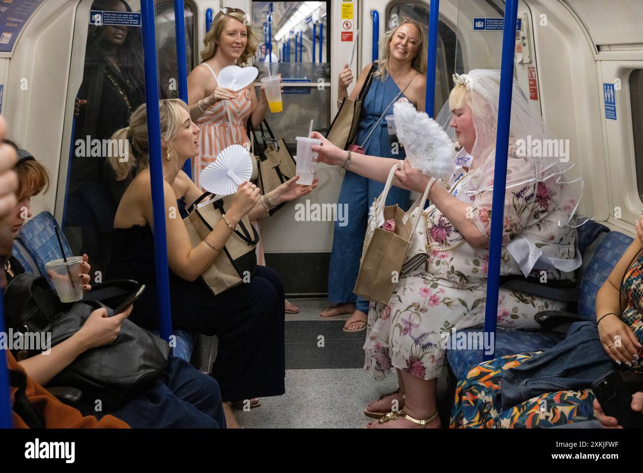 Hen party ladies travel together on London's Underground network on a busy warm summer weekend, London, England, United Kingdom Stock Photo