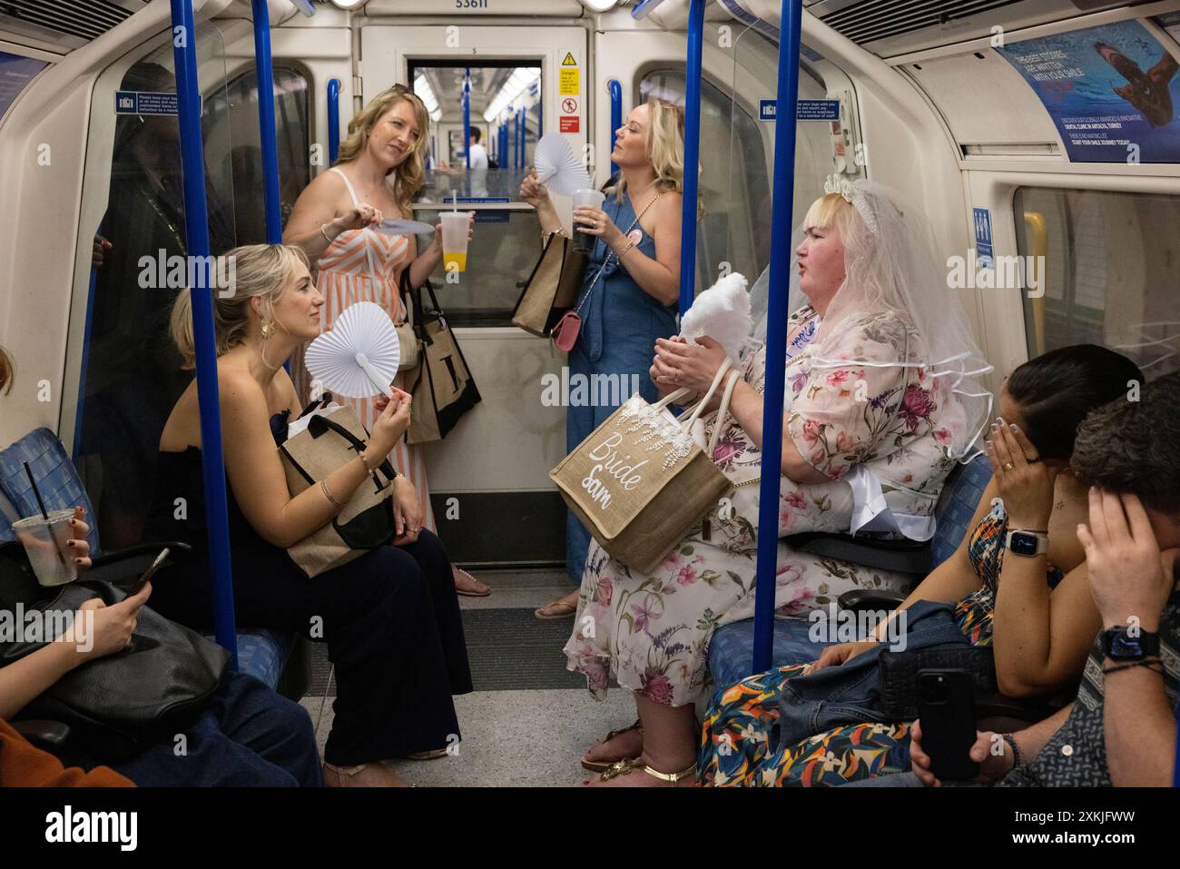 Hen party ladies travel together on London's Underground network on a busy warm summer weekend, London, England, United Kingdom Stock Photo