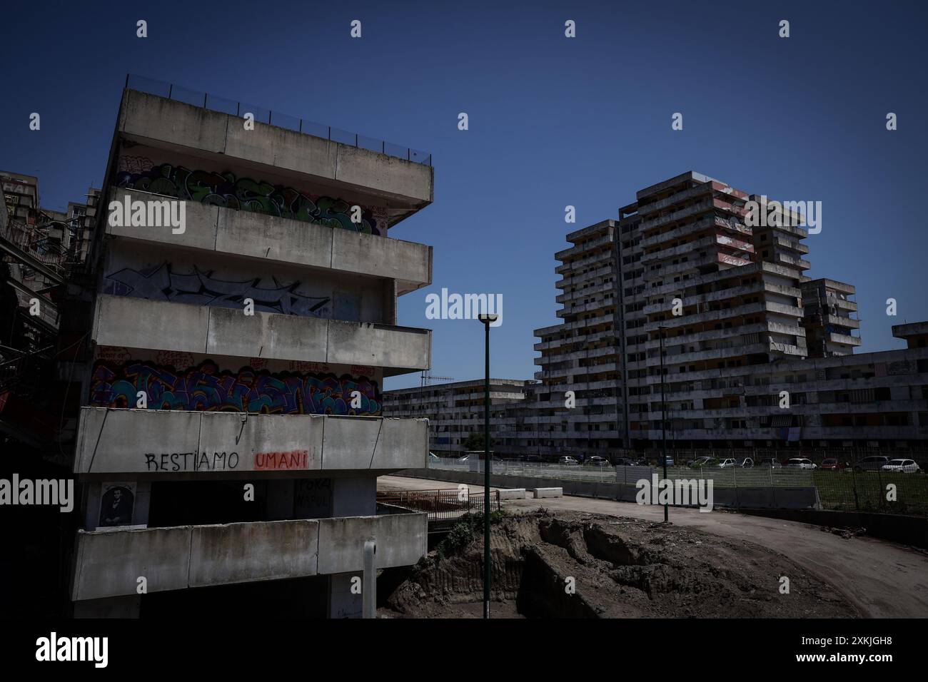 Le persone si radunano davanti a un edificio dove un passaggio pedonale in un massiccio progetto di edilizia residenziale è crollato nella città di Napoli, nel sud dell'Italia, martedì 23, 2024, uccidendo due persone e ferendone una dozzina di altre. Il crollo avvenuto nella notte ha coinvolto un nucleo familiare allargato, uccidendo un uomo di 29 anni e una donna di 35 anni. Lo riferisce l'agenzia ANSA. Tra i feriti ci sono sette bambini dai 2 ai 10 anni, due dei quali sono in terapia intensiva.(Photo by Alessandro Garofalo/LaPresse) Stock Photo