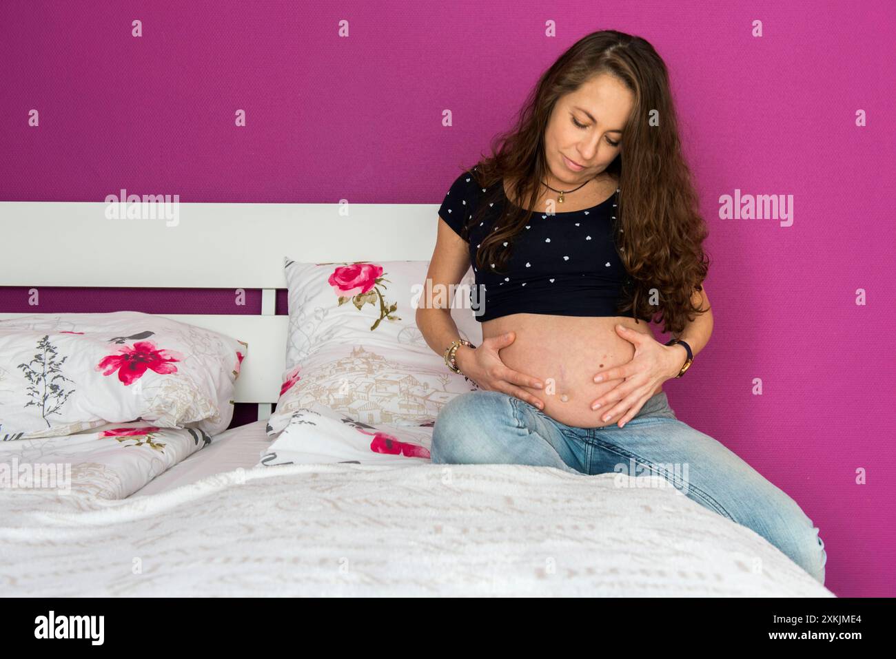 Portrait young, pregnant woman Young, pregnant woman and mother to, on het bedroom bed. Tilburg, Netherlands. MRYES Tilburg Kruizemuntweg Noord-Brabant Nederland Copyright: xGuidoxKoppesxPhotox Stock Photo