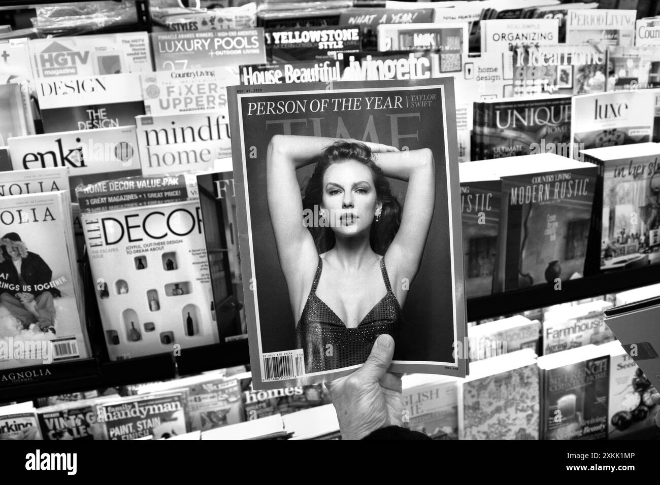 A bookstore customer holds up a copy of Time magazine with a cover photo of the magazine's 'Person of the Year,' Taylor Swift. Stock Photo