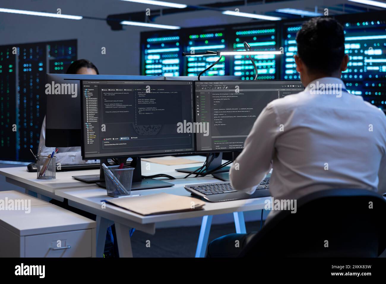 Technician using computer to troubleshoot hardware and software issues in server hub. IT expert implementing and maintaining server and network infrastructure in data center using PC Stock Photo