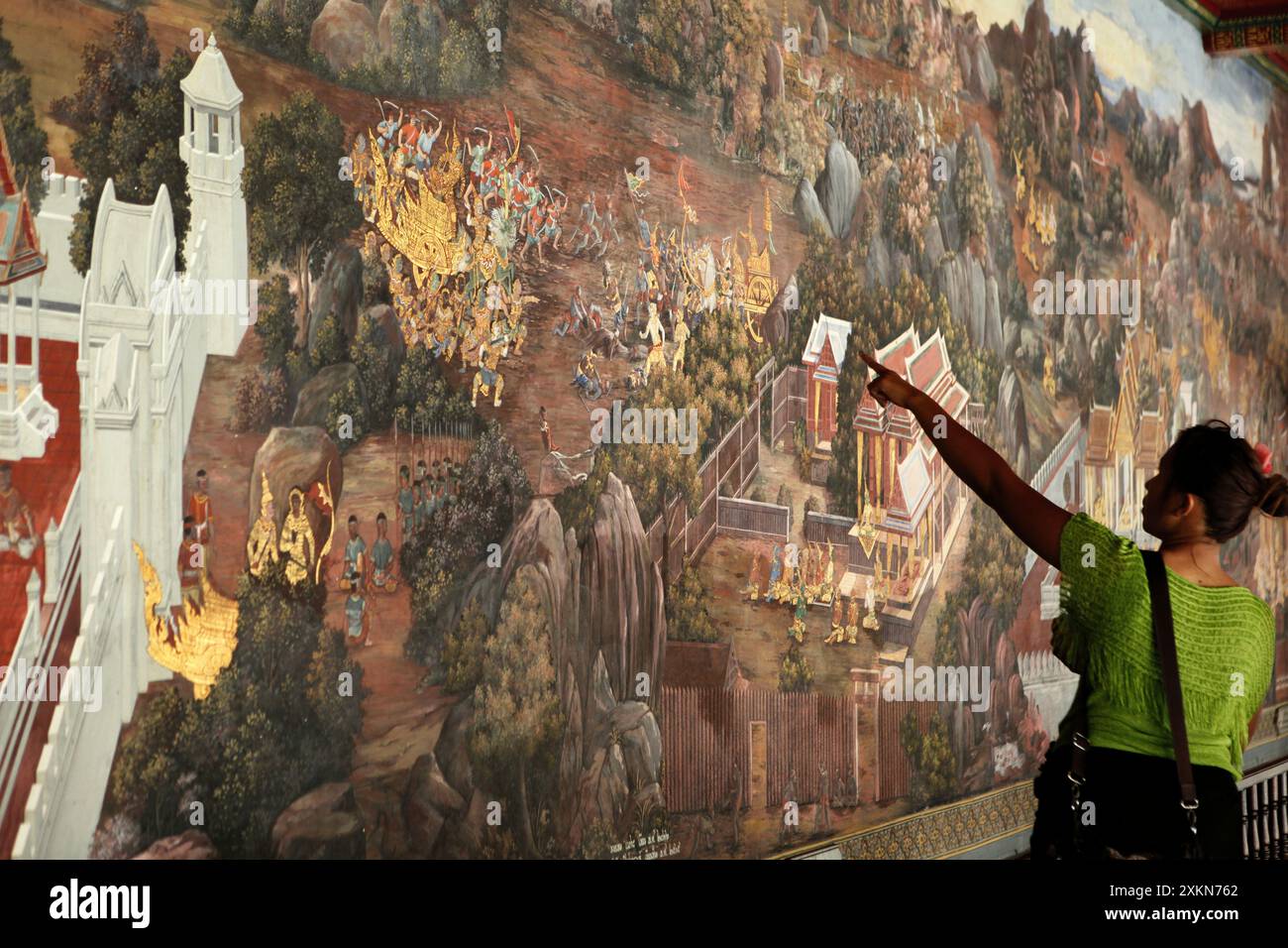 a-woman-visitor-points-out-a-scene-in-a-giant-painting-illustrating