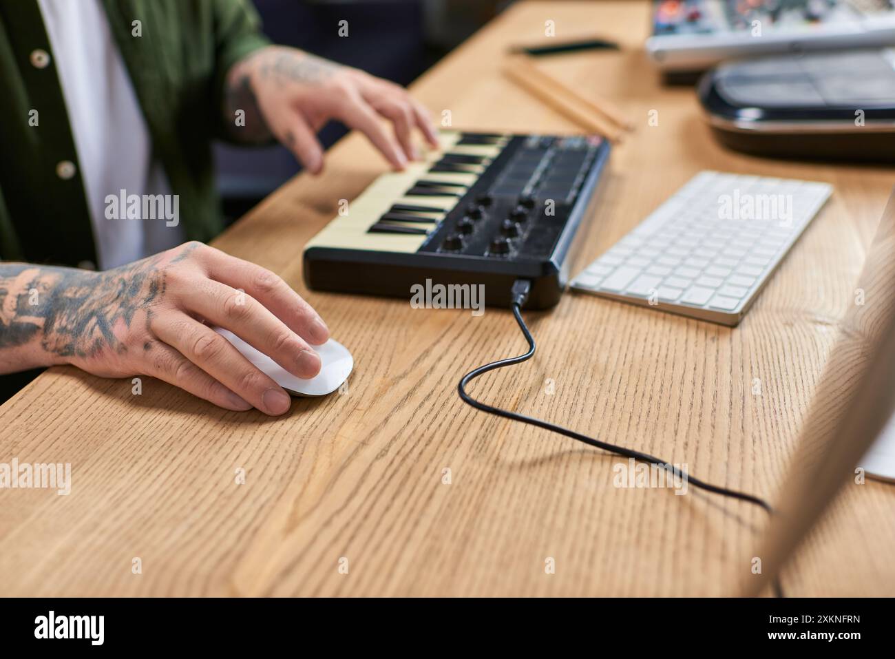 A close-up of an Asian mans hands working on music production in his studio. Stock Photo