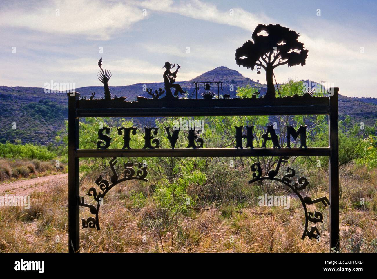 Wrought iron sign to commemorate a person at ranch entrance at dusk near Pandale, Pecos River Valley, Stockton Plateau in Val Verde County, Texas, USA Stock Photo