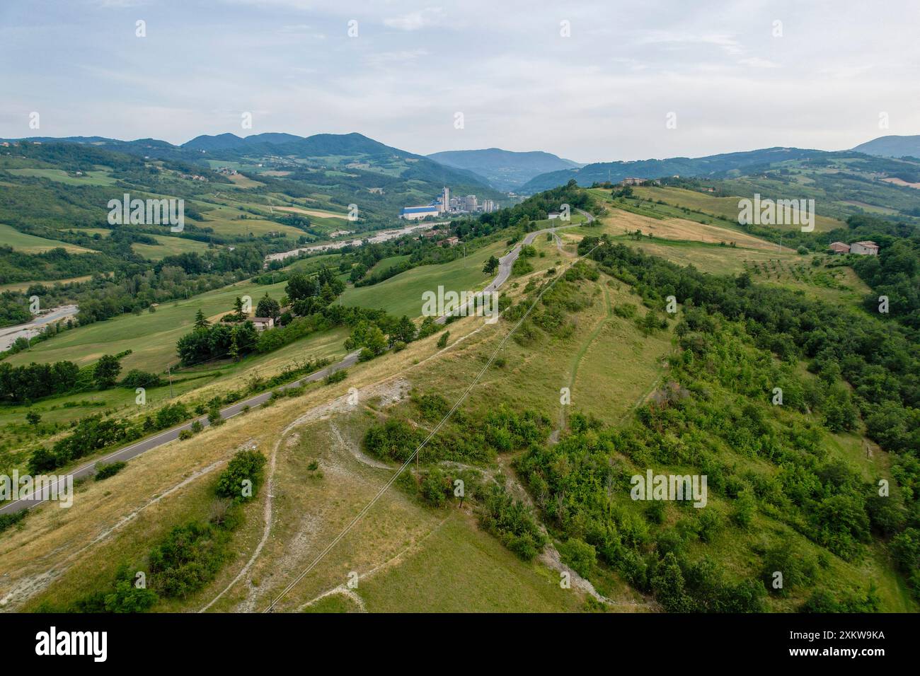 Aerial, An aerial view of a winding road cutting through lush green ...
