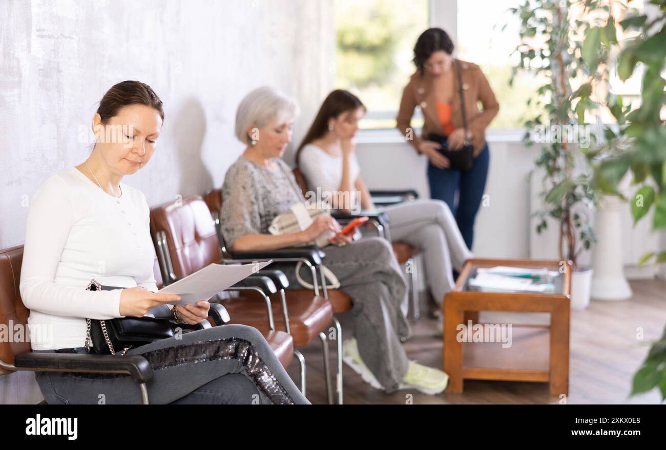 Young female employees sits in waiting room and waits for interview ...