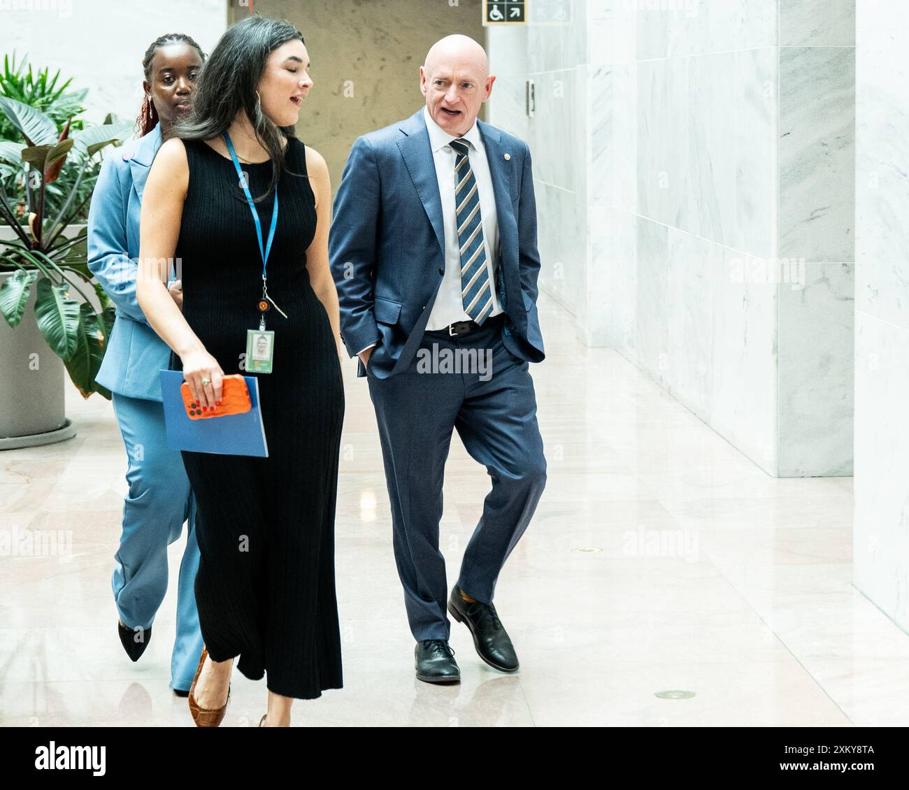 Washington, United States. 24th July, 2024. U.S. Senator Mark Kelly (D-AZ) speaking with staff while walking through the Hart Senate Office Building at the U.S. Capitol. Credit: SOPA Images Limited/Alamy Live News Stock Photo