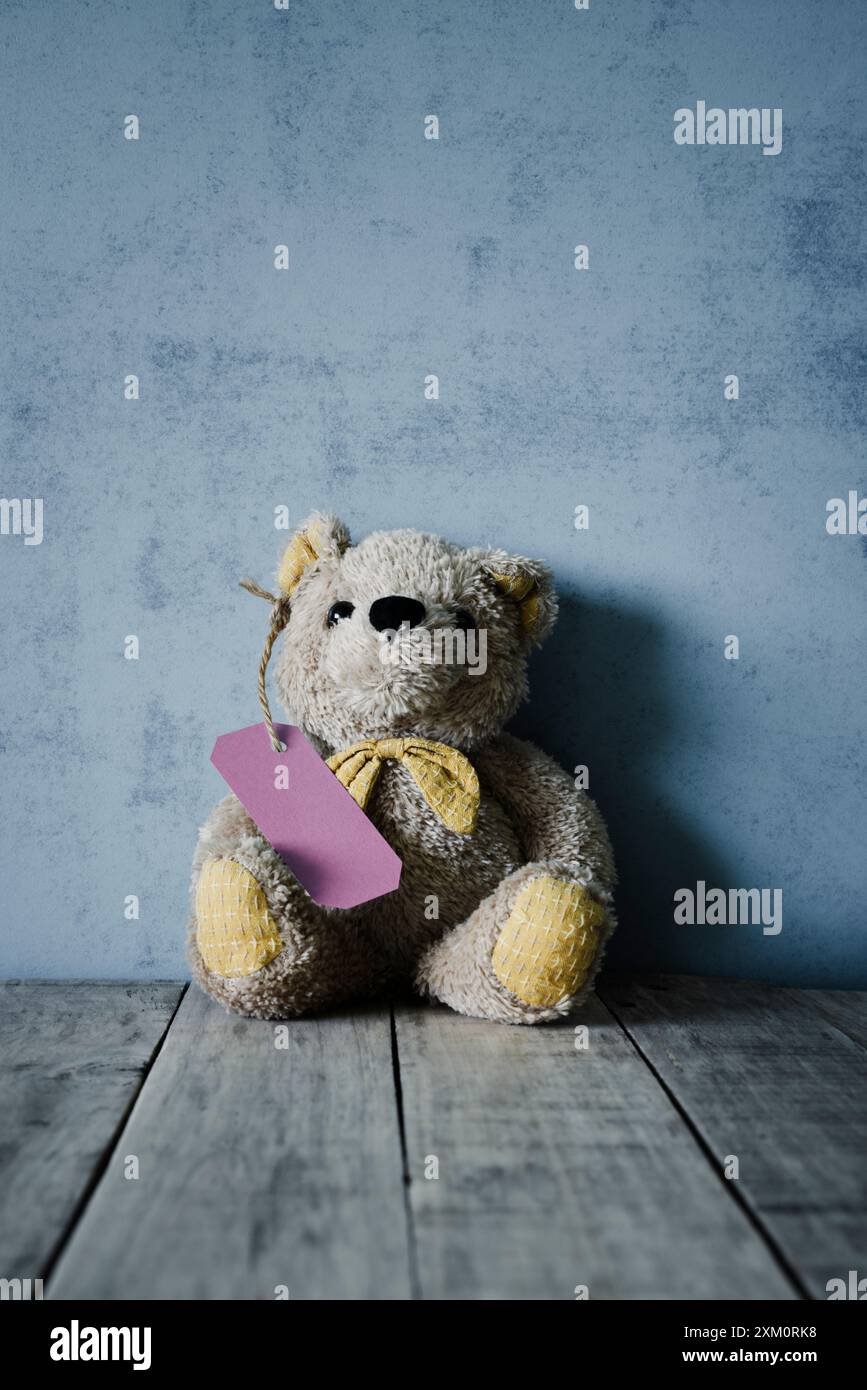 Teddy bear with a label attached. Stock Photo