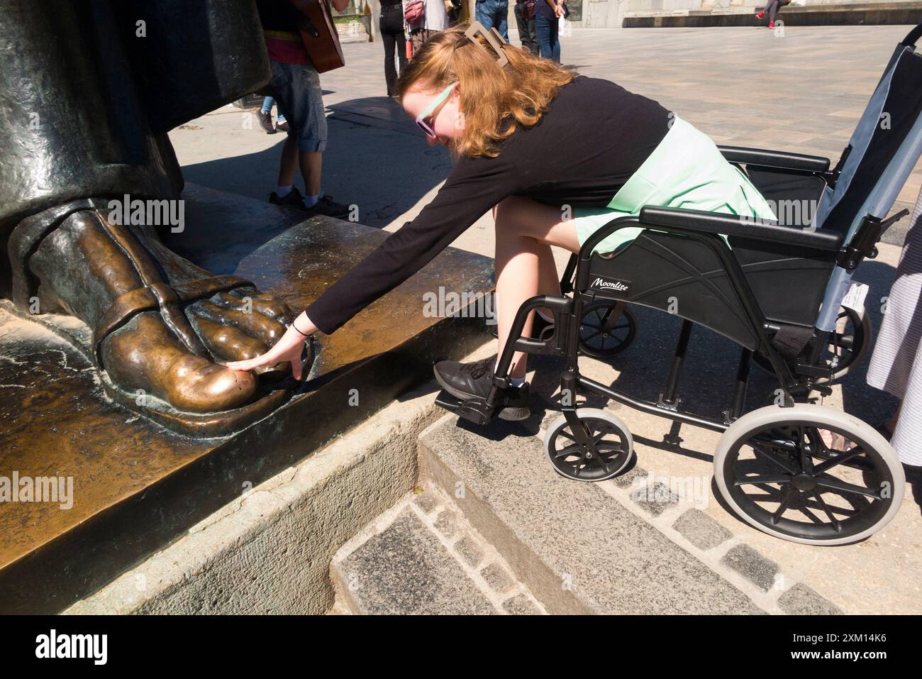 Touching big toe on foot for luck girl in wheelchair disabled child