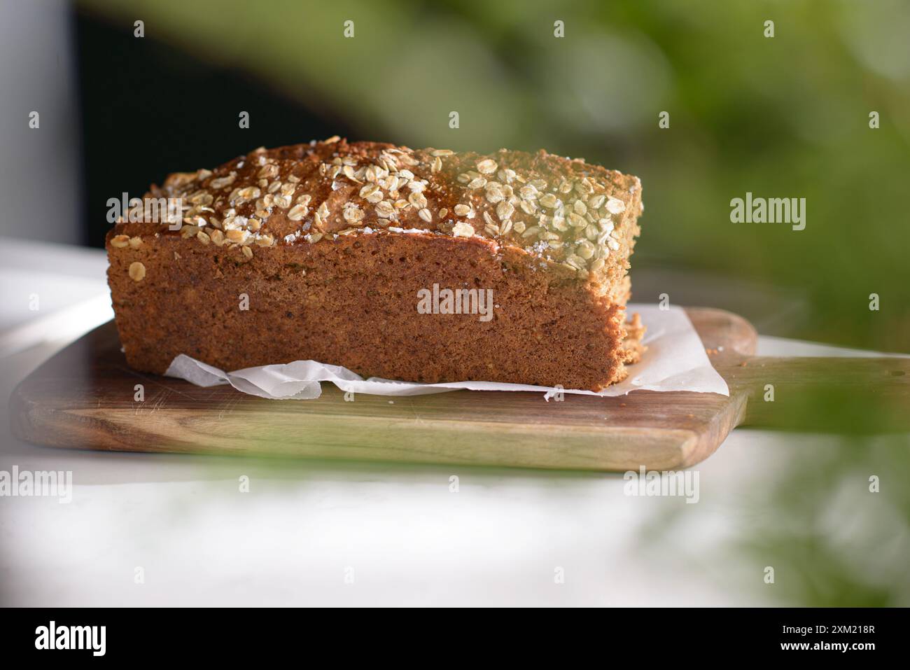 Whole Grain rye bread with seeds on a cutting board. Dark background. Stock Photo