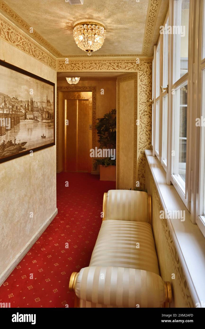 Corridor with a divan under a window, small chandeliers and decorative paint finish in a luxury hotel palazzo in Prague Stock Photo