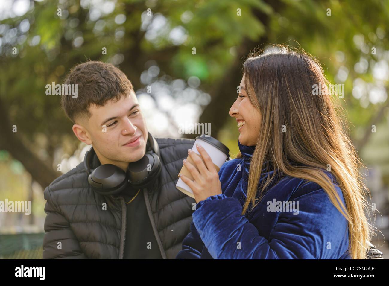 Happy caucasian boy and latina girl bench of a public park Stock Photo ...