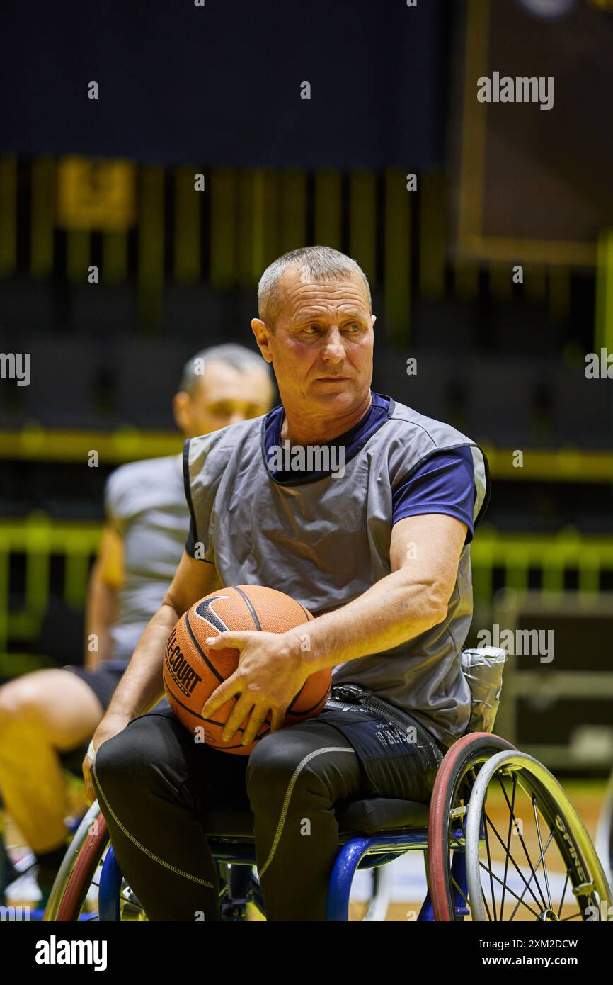 Paralyzed athlete playing basketball in a wheel chair. Kyiv - 12 ...