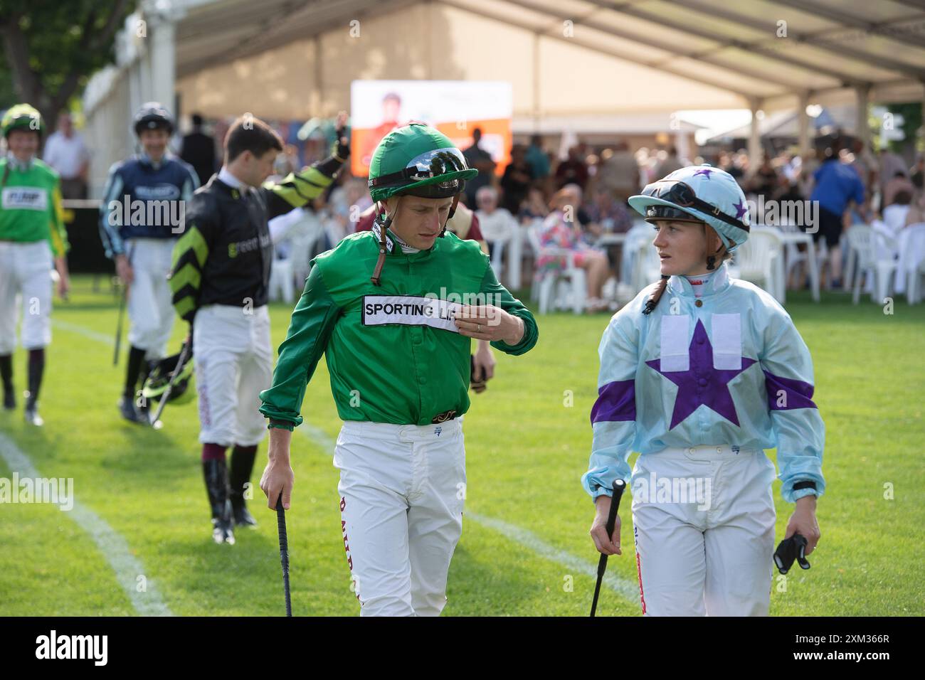 Windsor, Berkshire, UK. 22nd July, 2024. Husband and wife jockeys Tom Marquand and Hollie Doyle head to the Parade Ring for the Download the Raceday Ready App Nursery Handicap Stakes at Royal Windsor Racecourse in Windsor, Berkshire. Credit: Maureen McLean/Alamy Stock Photo