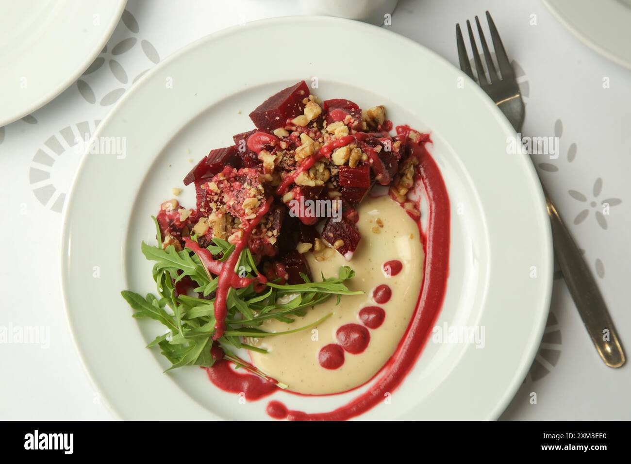 Beetroot salad served with hummus and fresh arugula Stock Photo