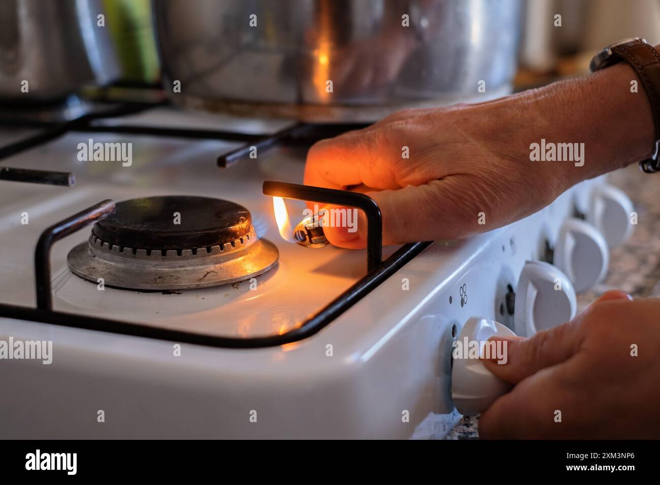 hand adjusting gas burning from a kitchen gas stove Stock Photo