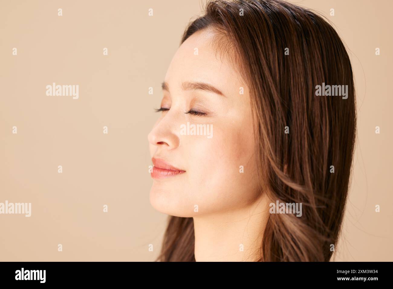 Asian Woman With Her Eyes Closed And Her Head Tilted Up Stock Photo