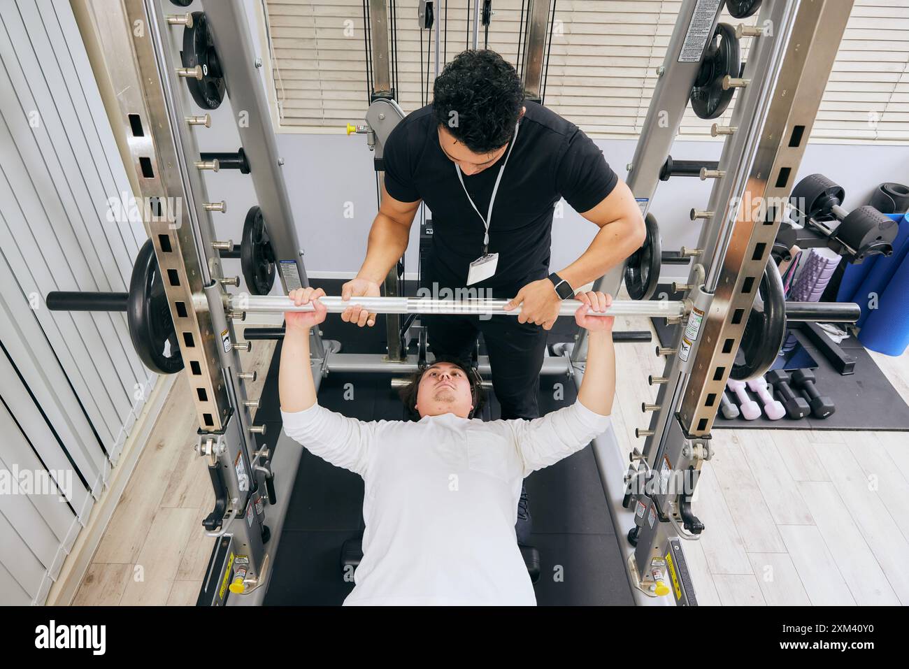 Asian Man Doing A Bench Press With Trainer Stock Photo - Alamy
