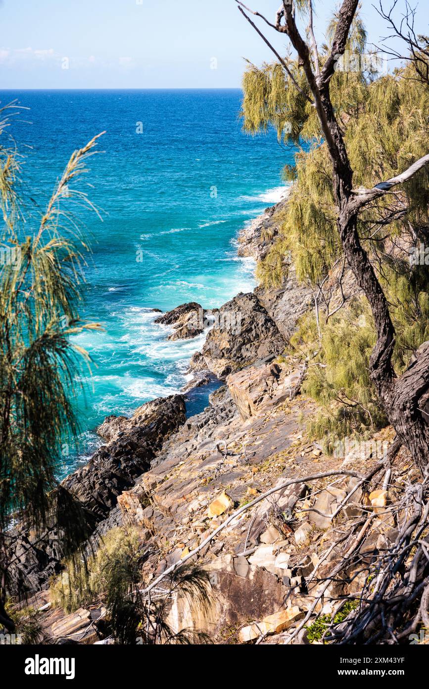 Waves crash on rocks on the hiking trail in Noosa National Park, Queensland, Australia. Stock Photo