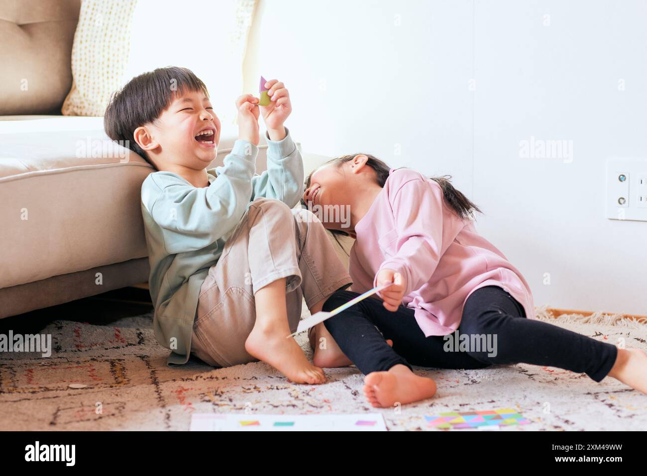 Happy Japanese kids playing on the floor Stock Photo