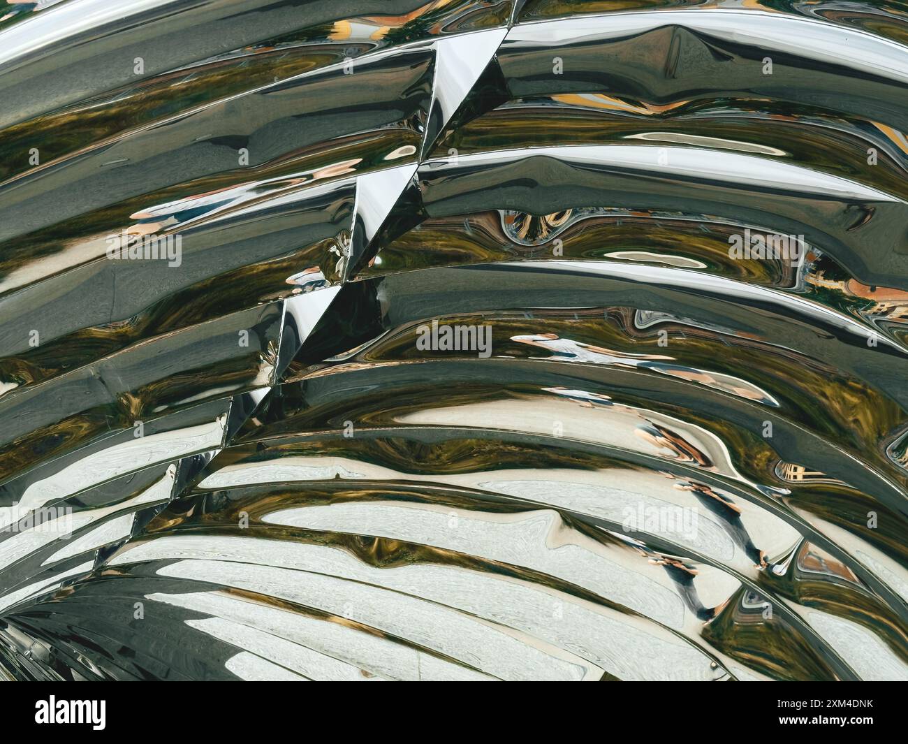 Close-up of a curved metal art installation, featuring intricate patterns and light reflections, showcasing modern design and innovative use of materials. Stock Photo