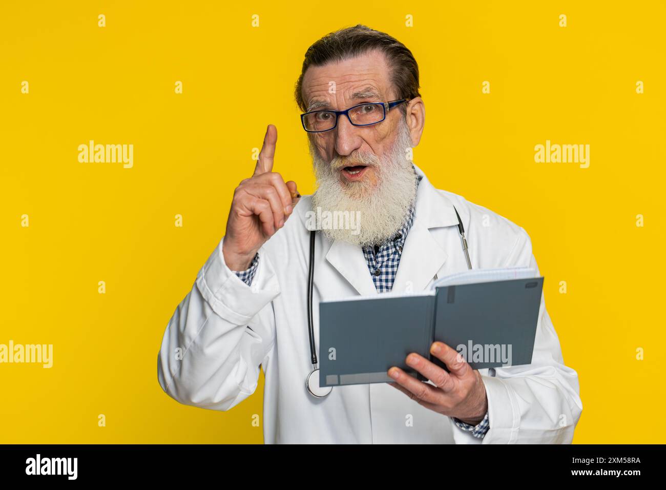 Thoughtful senior elderly doctor cardiologist man making notes, writing ...