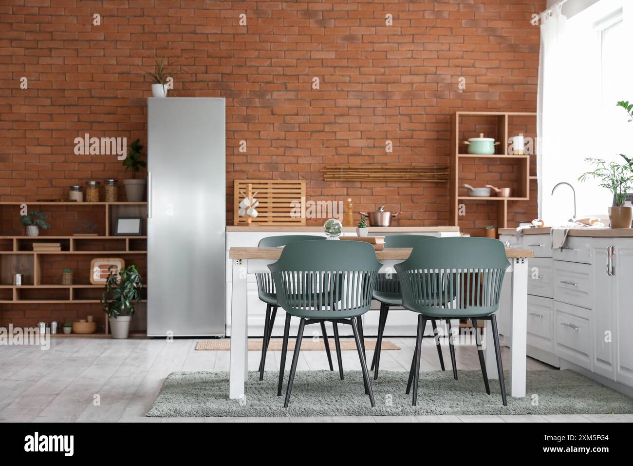 Interior of modern kitchen with dining table, fridge and shelving unit ...