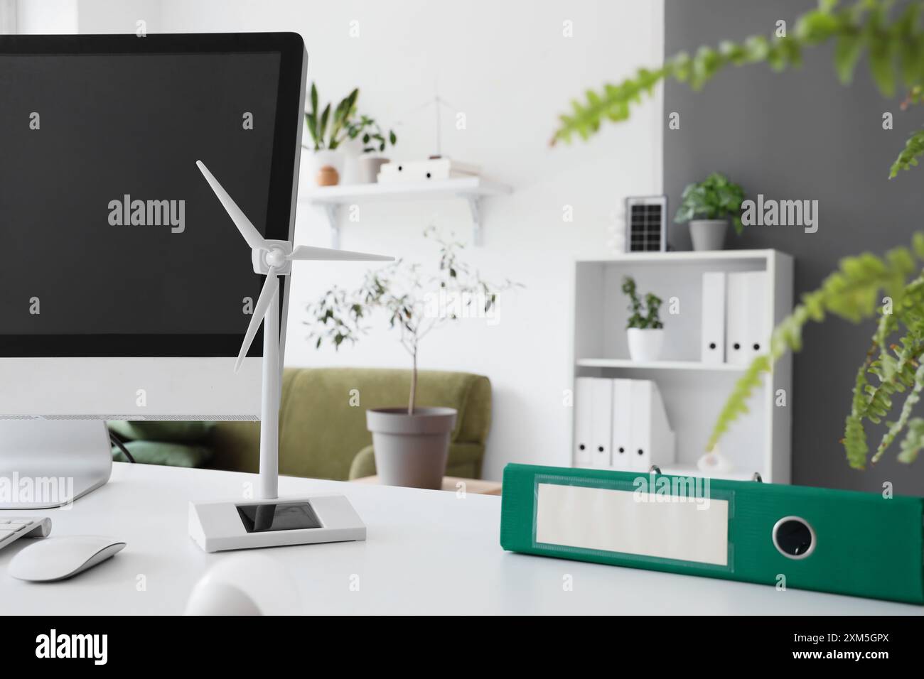 Wind turbine model with folder on engineer's table in office, closeup Stock Photo
