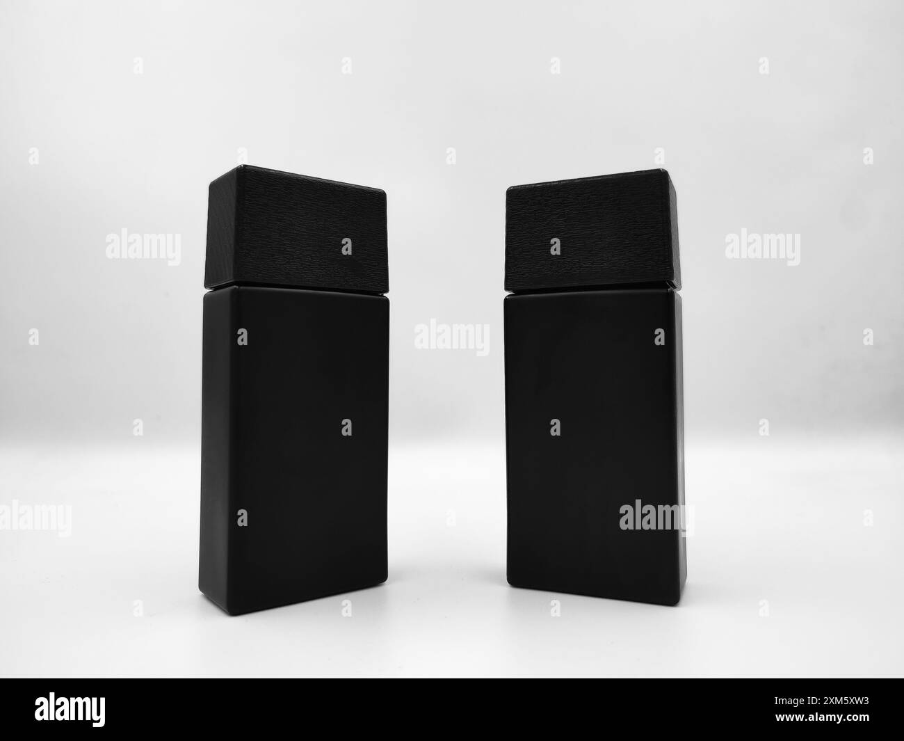 Two black perfume bottle template isolated on white background. Mockup image close up shot on photo studio with indoor lighting Stock Photo