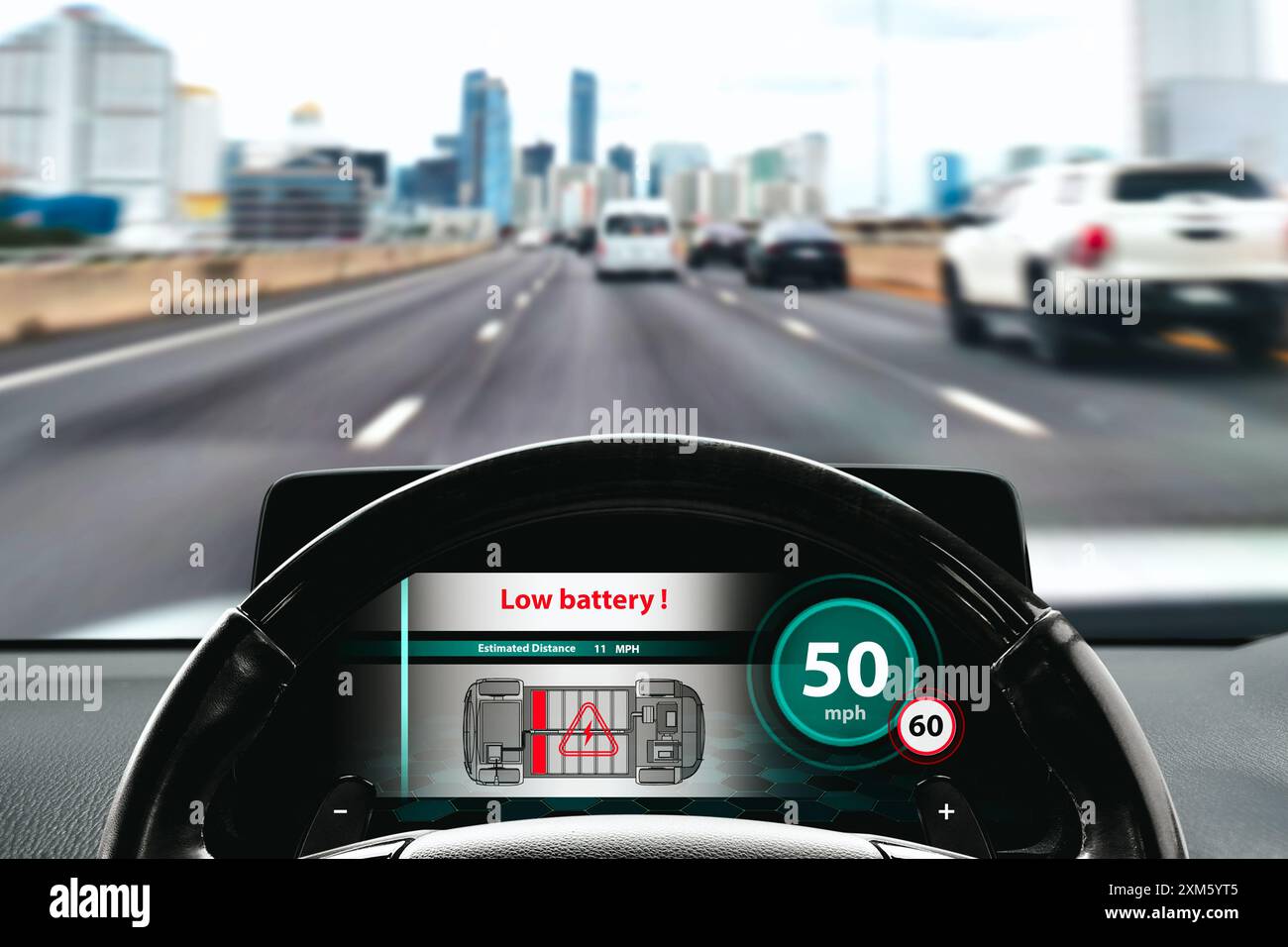 Low battery warning on the screen of an EV electric car , Electric car with low estimated range driving on the highway at daytime , EV electric car te Stock Photo