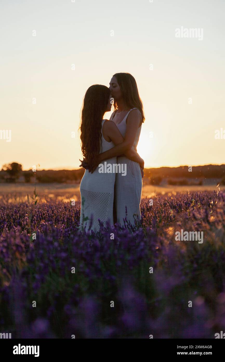 Two women are enjoying a serene moment in a blooming lavender field at ...