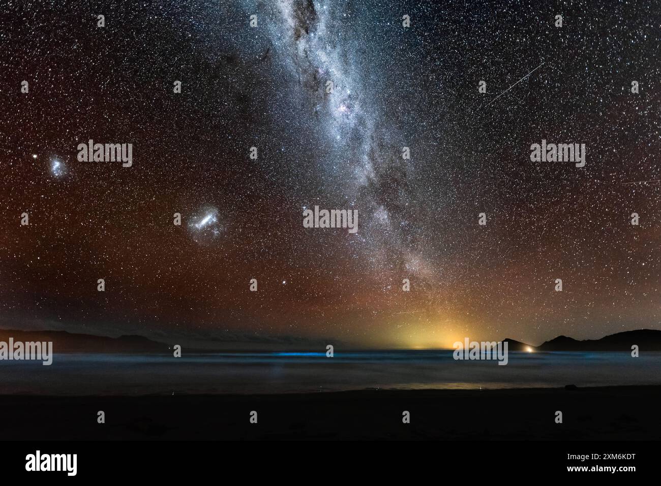Magellanic Clouds and Milky Way galaxies over bioluminescence Stock ...