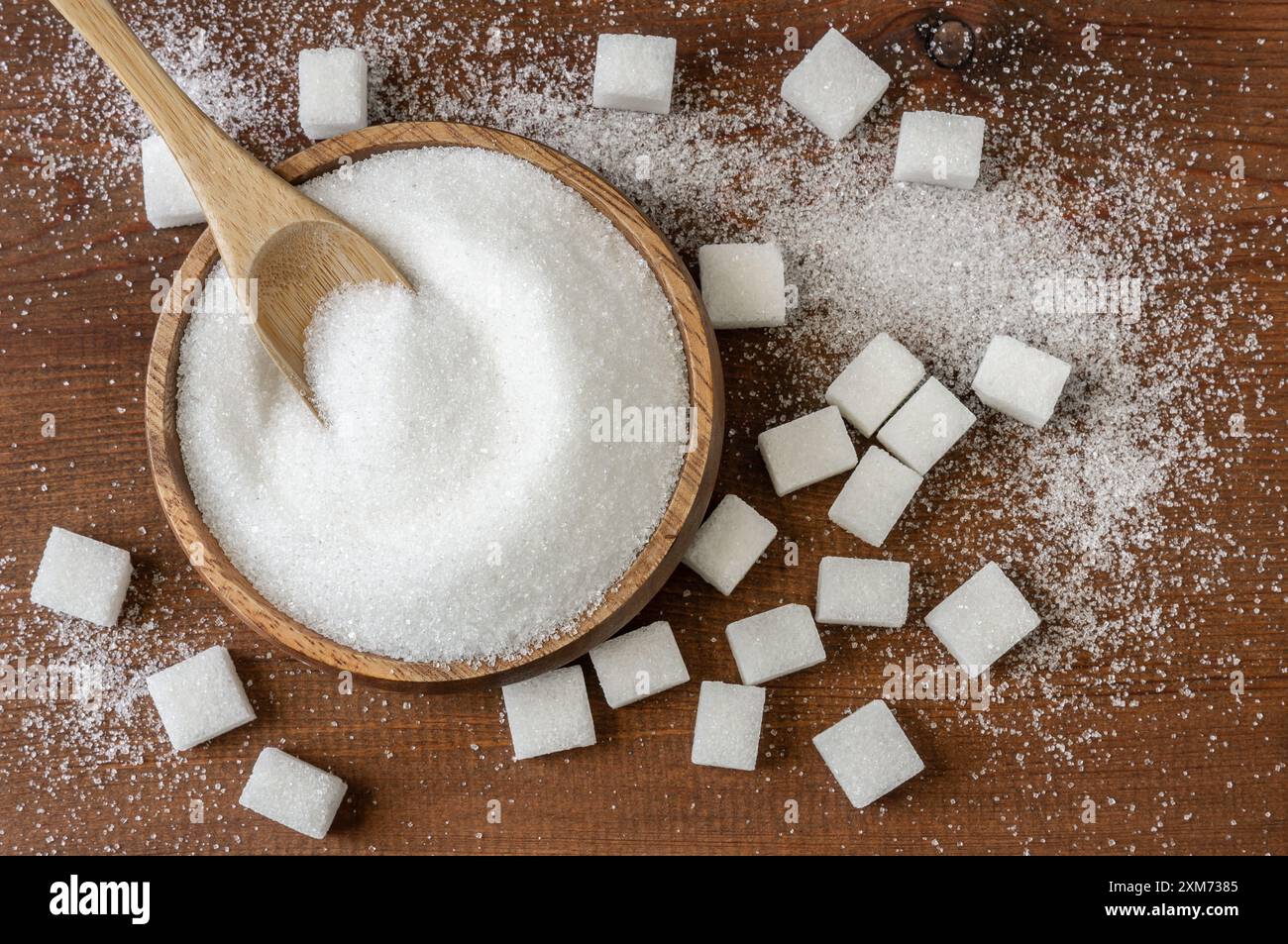 Heap of white granulated sugar in spoon and bowl with sugar cube Stock Photo