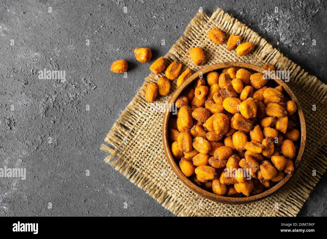 Roasted salted Corn Nuts with Spice and Sauce in bowl on rustic table, Nut concept Stock Photo