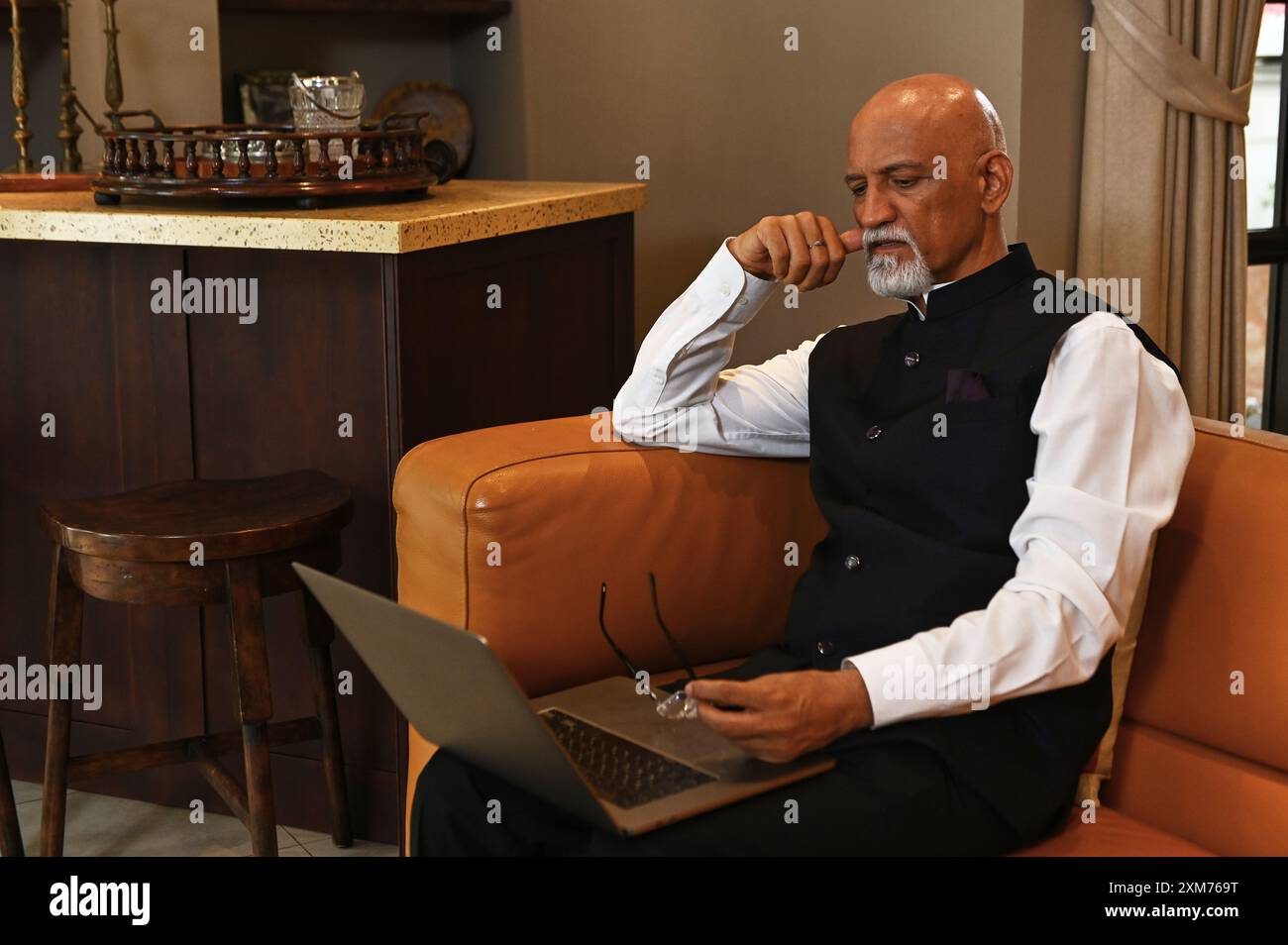 Indian Man Using Laptop At Home Stock Photo