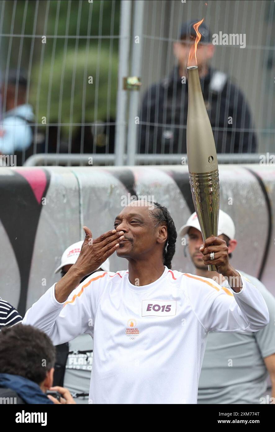 Paris, France. July 26, 2024. US rapper Snoop Dogg holds the torch ...